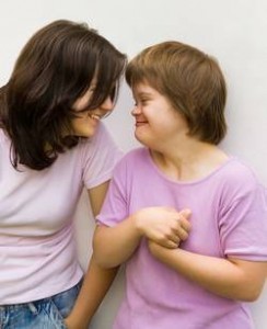 photo de deux jeunes femmes dont une est trisomique qui se sourient